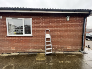 External elevation showing the affected room window, roof edge, guttering/downpipe and external wall.