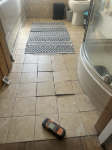 Overall view of the bathroom and tiled floor, showing the room context in which the concealed defect was investigated. Useful as a contextual rather than principal image